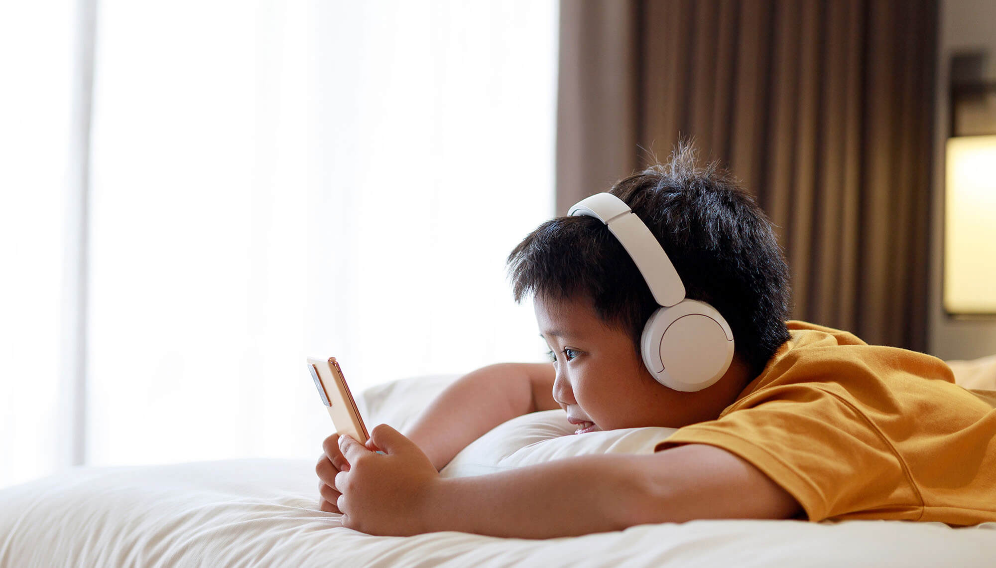 Bạn nhỏ nghe nhạc bằng tai nghe Bluetooth