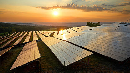 Photovoltaic panels of solar power station in the landscape at sunset. View from above.